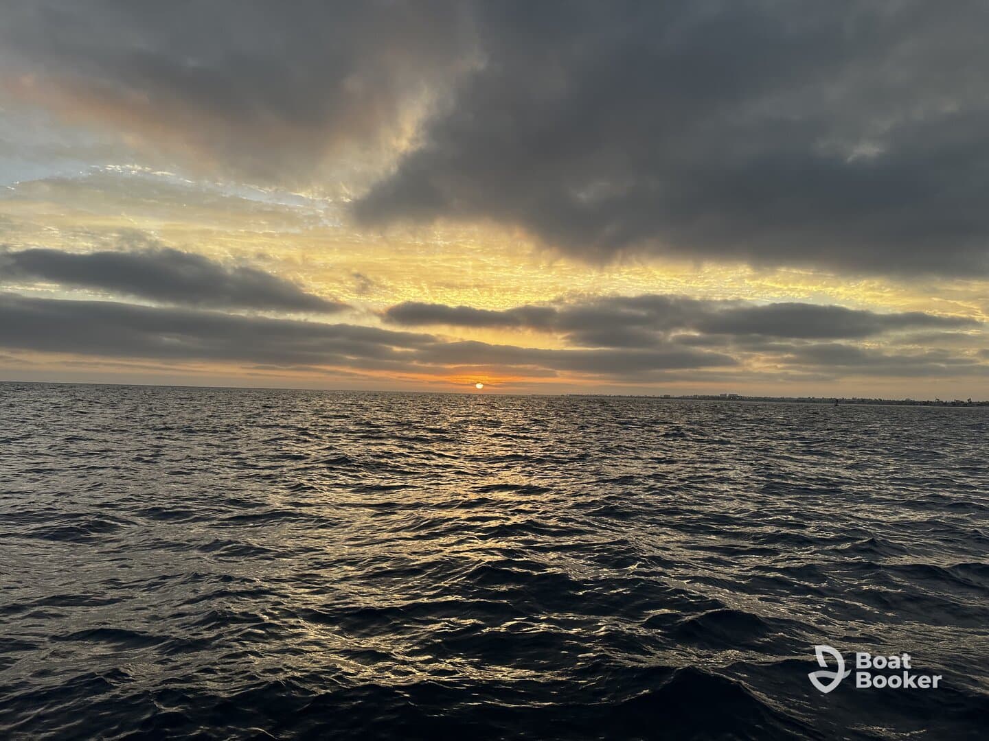 A serene sunset over the ocean, capturing the tranquil beauty of the water and sky — perfect for peaceful evening boat rides.