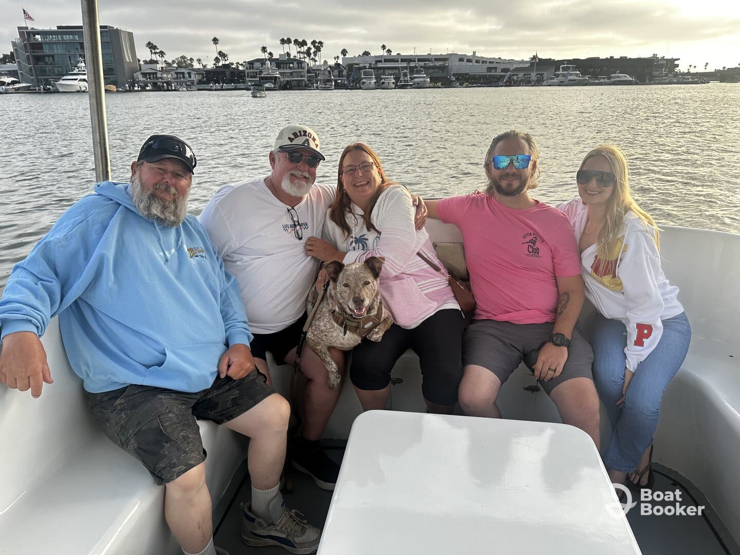 A cheerful group of friends enjoys a relaxing moment on a boat, accompanied by a dog, showcasing the joy of shared experiences on the water.