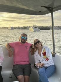 A couple enjoys a scenic boat ride at sunset, capturing the essence of relaxation and celebration on the water.