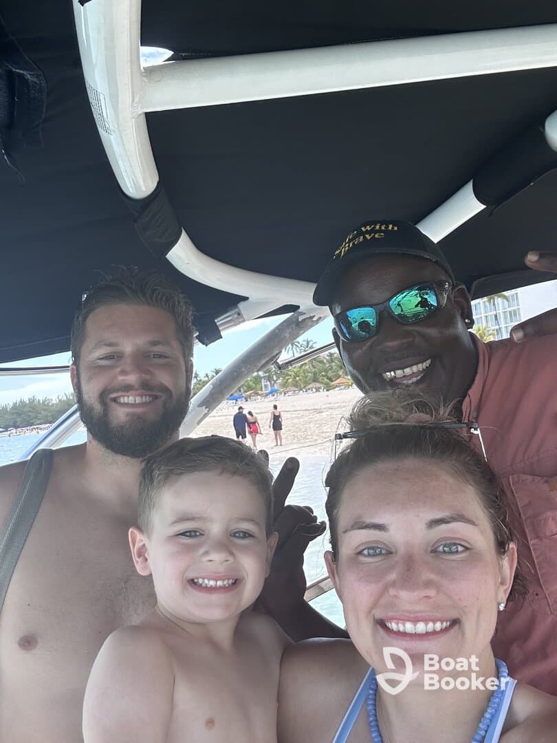 A joyful family poses for a selfie on a boat, capturing a fun day at the beach with smiles all around.