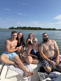 A lively group of friends enjoys a sunny day on the boat, capturing the essence of summer fun and camaraderie on the water.