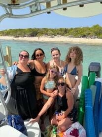 A joyful group of friends and family poses on a boat, ready for a fun day at the beach — perfect for creating lasting memories on the water.