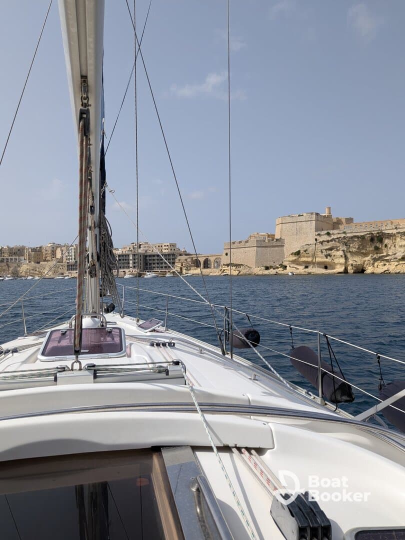 A stunning view from the deck of a sailboat, showcasing the vessel's structure as it navigates near a historic coastal fortification.