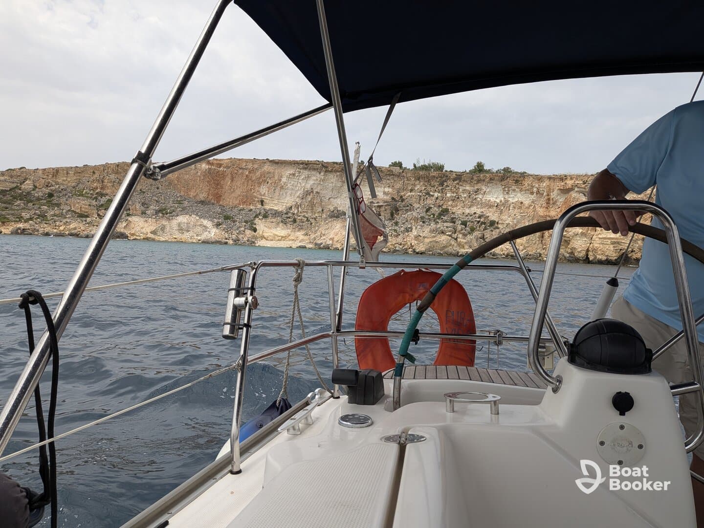 A scenic view from the helm of a sailboat, showcasing a stunning cliffside landscape while sailing — perfect for adventure seekers and nature lovers.