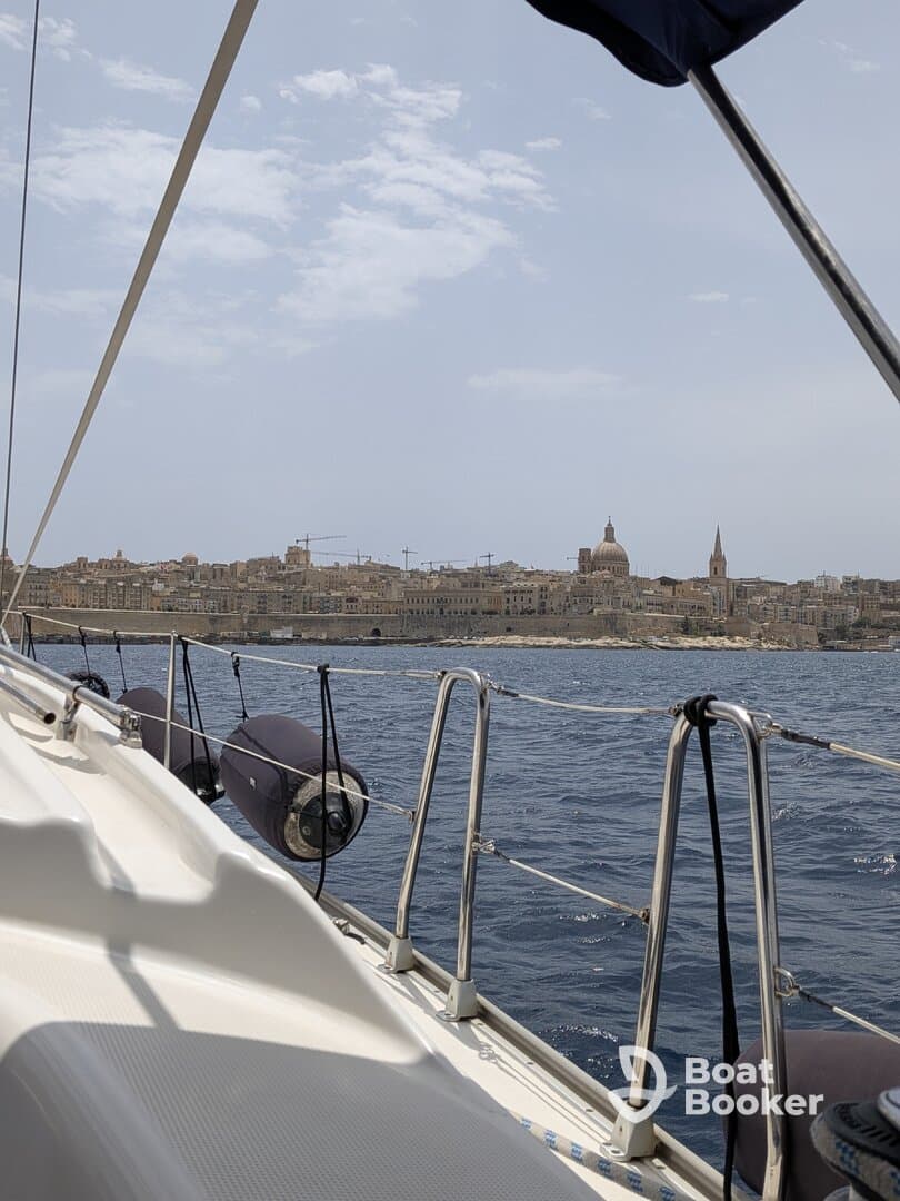 A scenic view from a sailboat showcasing the coastline and architecture of a coastal city, perfect for those exploring by sea.