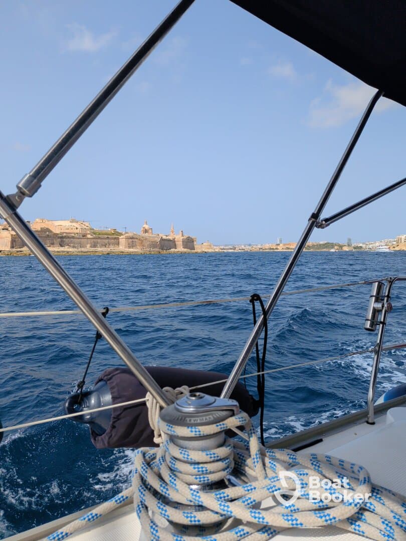 A scenic view from a sailboat showcasing the coastline and historical architecture in the background, perfect for capturing the essence of a sailing adventure.