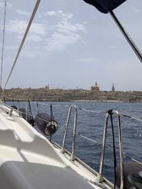 A scenic view from a sailboat showcasing the coastline and architecture of a coastal city, perfect for those exploring by sea.
