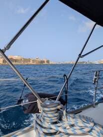 A scenic view from a sailboat showcasing the coastline and historical architecture in the background, perfect for capturing the essence of a sailing adventure.