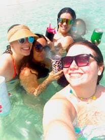 A fun group of friends enjoys a lively day in the water, sipping cocktails and celebrating together — perfect for summer outings and beach parties.