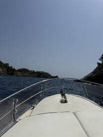 A view from the front of a boat cruising through open waters, showcasing the stunning coastal landscape ahead.