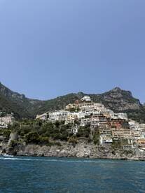 A stunning view of the picturesque coastal town of Positano, showcasing its colorful buildings perched on the cliffs, perfect for travelers seeking scenic beauty along the Amalfi Coast.
