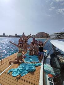 A lively group of friends celebrates on the deck of a yacht, enjoying drinks and fun in the sun — perfect for a memorable day on the water.