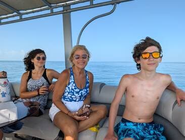 A cheerful family enjoys a sunny day on a boat, capturing the essence of relaxation and fun on the water.