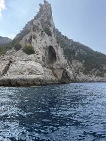 A stunning view of a rocky coastline with a prominent cliff, showcasing the natural beauty of the area — perfect for scenic boat tours and exploration.