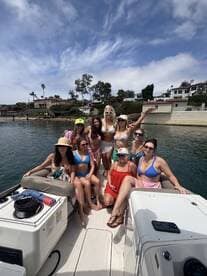 A lively group of friends enjoys a fun day on the boat, showcasing the perfect atmosphere for celebrations and summer outings.