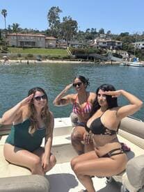 A fun group of friends poses on a boat, enjoying a sunny day on the water — perfect for summer celebrations and outings.