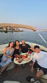 A cheerful group enjoys a delightful spread of food and drinks on a boat, perfect for celebrating special moments on the water.
