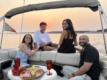 A joyful family enjoys a sunset cruise on a boat, sharing delicious food and drinks while creating lasting memories together.