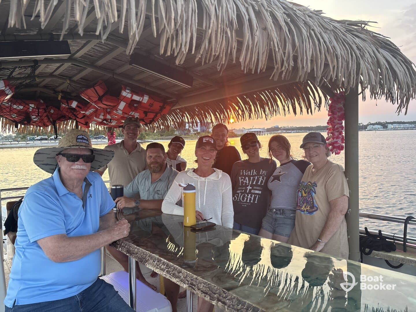 A cheerful group of friends gathers on a boat during sunset, enjoying each other's company and the beautiful waterfront view — perfect for memorable outings and celebrations.