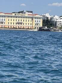 A distant view of the Hyatt Regency building from the water, with unclear details due to the angle and distance.