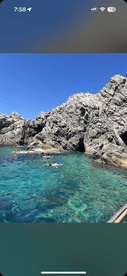 Snorkelers explore the vibrant underwater world near a rocky coastline, showcasing the beauty of clear waters and marine life — a perfect adventure for water enthusiasts.