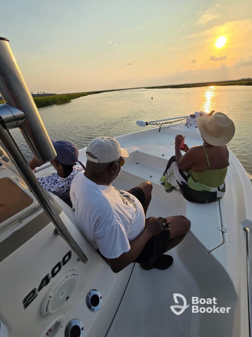 A group enjoys a serene sunset view from their boat, creating a perfect backdrop for relaxation and memorable moments on the water.