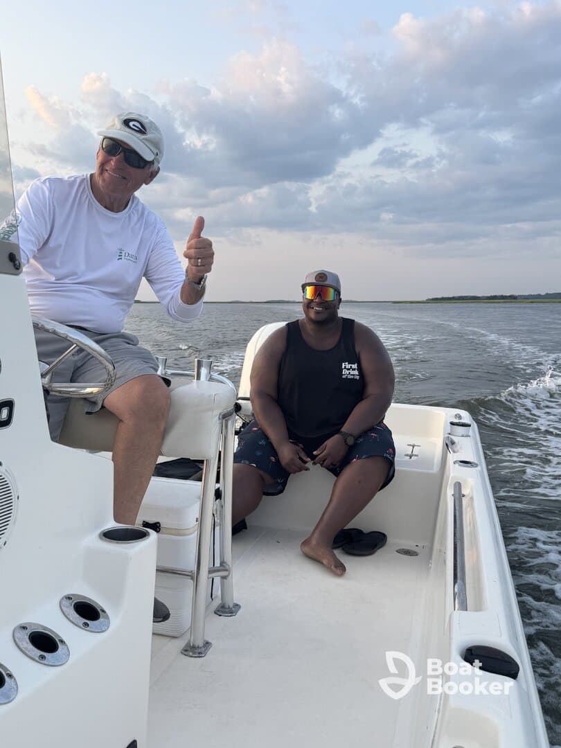 Two friends enjoy a day on the water, smiling and sharing a moment aboard a fishing boat — perfect for creating lasting memories on the water.