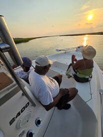 A group enjoys a serene sunset view from their boat, creating a perfect backdrop for relaxation and memorable moments on the water.