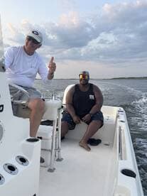 Two friends enjoy a day on the water, smiling and sharing a moment aboard a fishing boat — perfect for creating lasting memories on the water.