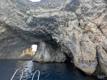 A stunning view of a natural cave formation along the coastline, showcasing the beauty of the surrounding waters — perfect for eco tours and scenic boat trips.