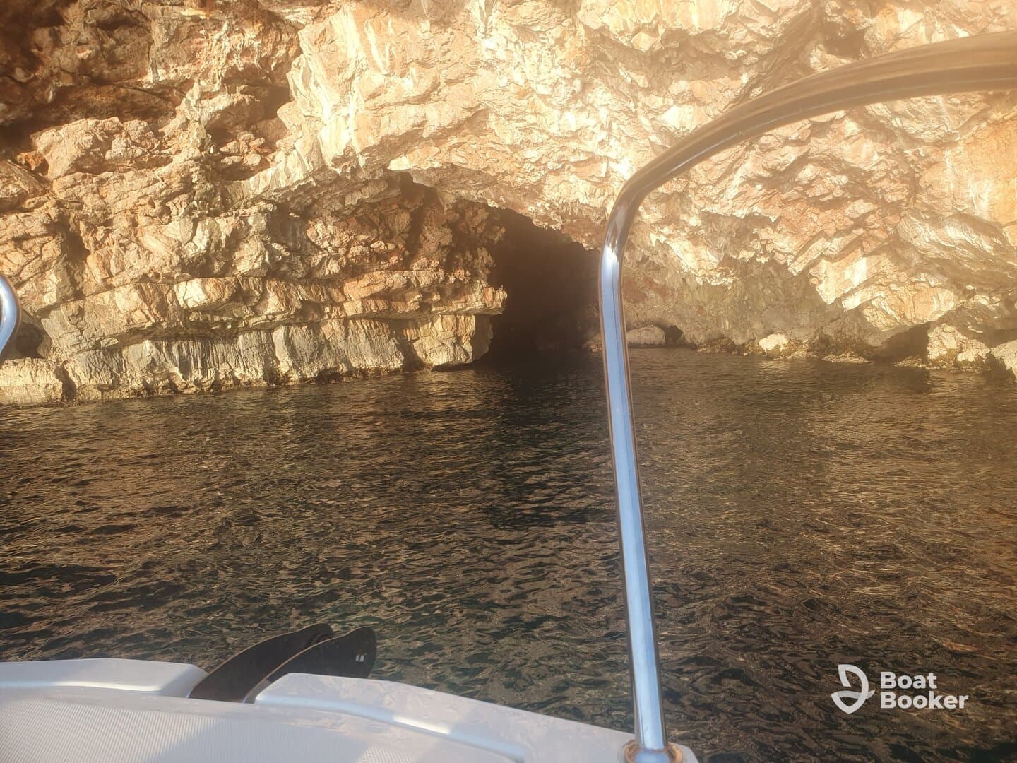 A scenic view of a rocky coastline with a cave entrance, captured from a boat — perfect for exploring hidden gems along the shore.