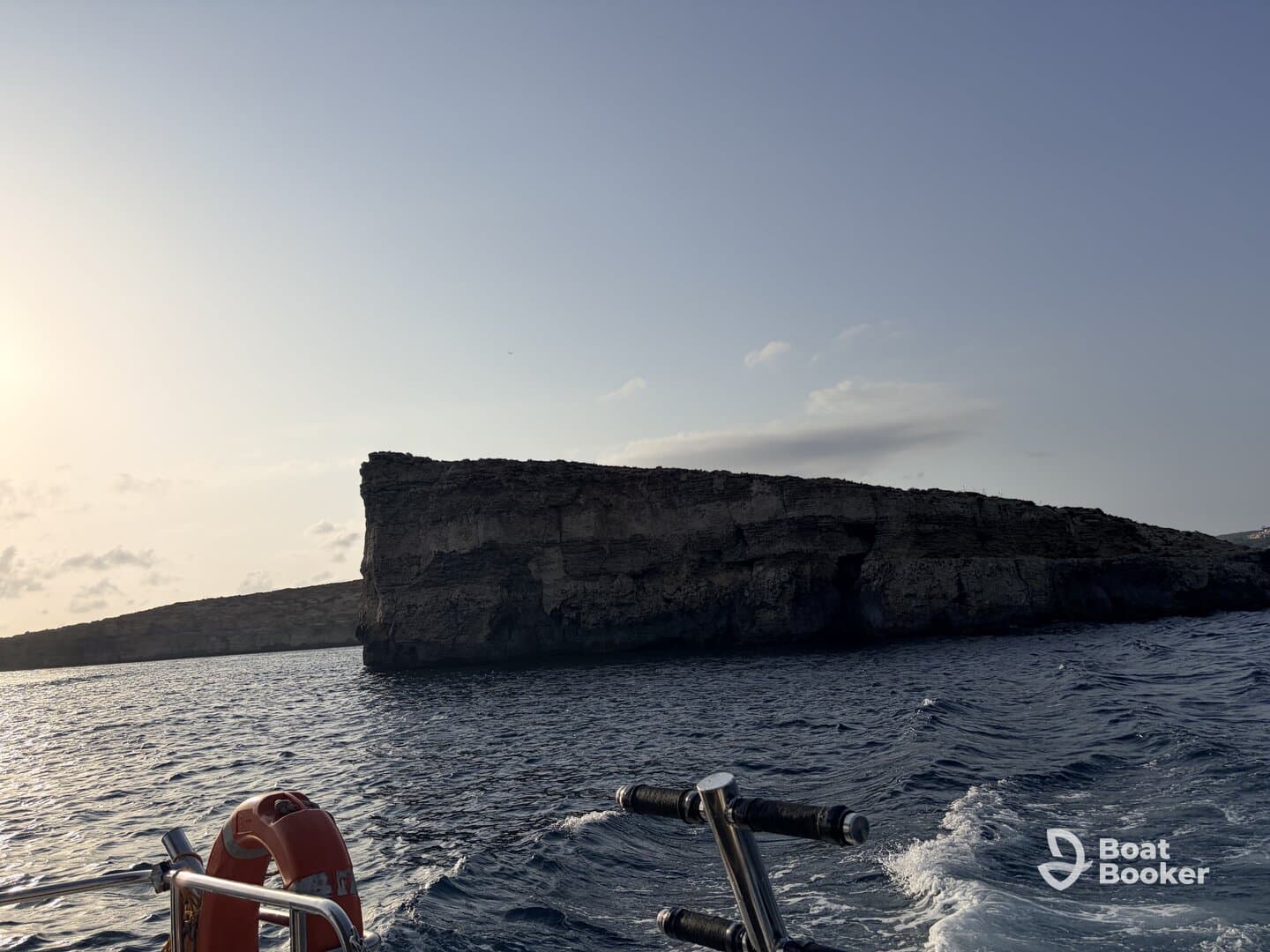 A stunning view of a rocky coastline at sunset, showcasing the natural beauty of the area — perfect for scenic boat tours and exploration.
