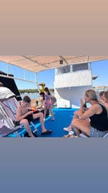 A lively group enjoys a relaxing day on the boat, with drinks in hand and laughter all around — perfect for family outings and summer adventures.