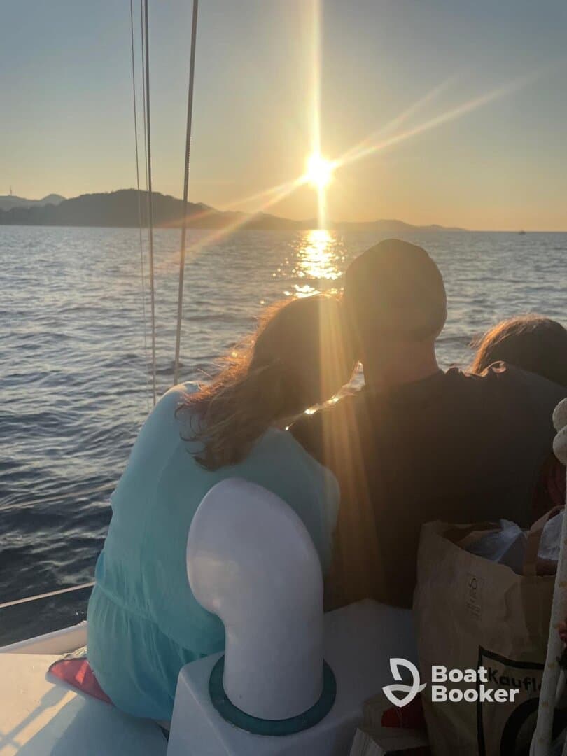 A couple enjoys a romantic moment watching the sunset from their boat, creating a perfect backdrop for memorable experiences on the water.