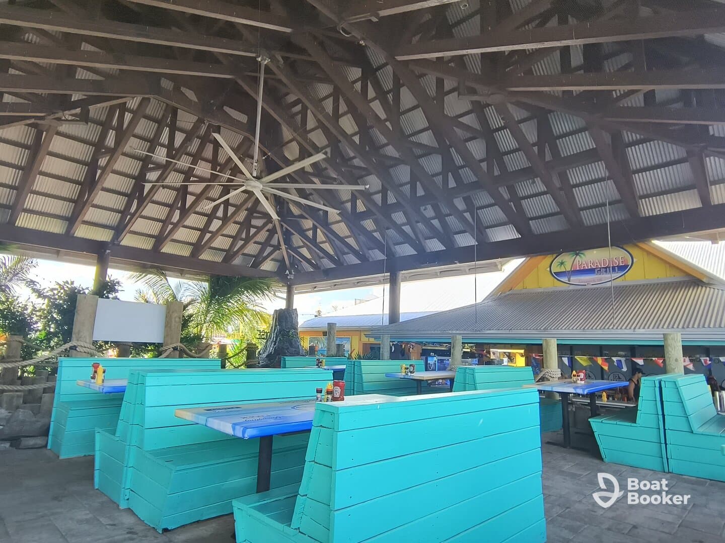 A vibrant interior view of a boat-themed dining area featuring turquoise seating and a spacious layout, perfect for enjoying meals in a relaxed atmosphere.