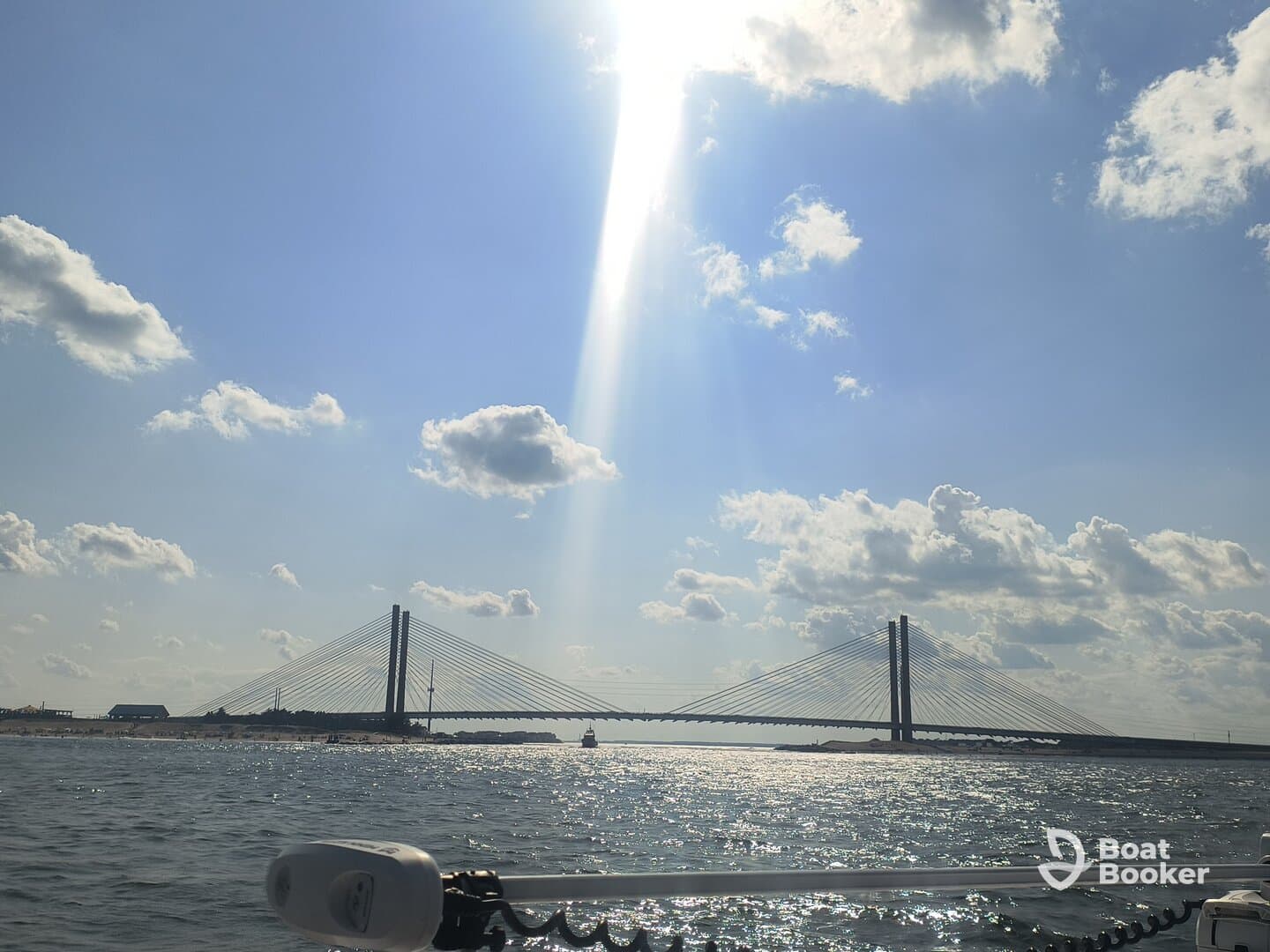 A stunning view of a bridge over shimmering waters, illuminated by sunlight — a perfect representation of a scenic boating experience.