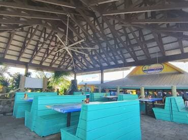 A vibrant interior view of a boat-themed dining area featuring turquoise seating and a spacious layout, perfect for enjoying meals in a relaxed atmosphere.