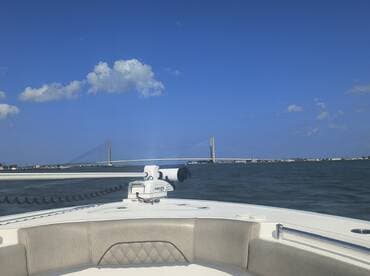 A scenic view from the deck of a boat, showcasing a bridge against a clear blue sky — perfect for capturing the essence of a day on the water.