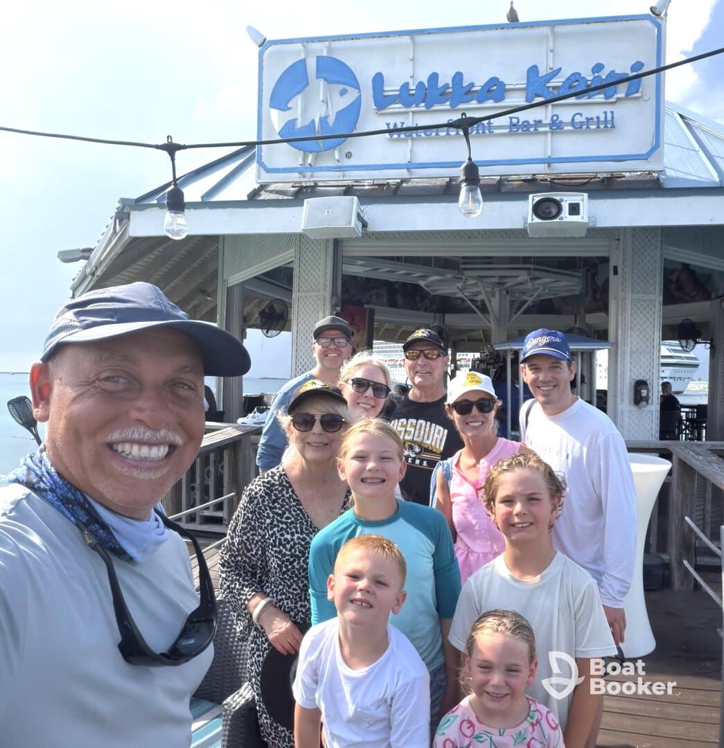 A cheerful group of family and friends poses for a selfie at Lukka Kairi Waterfront Bar & Grill, capturing a memorable moment by the water.