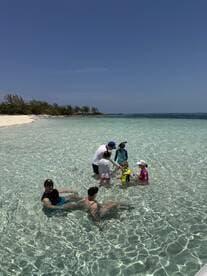 A joyful family enjoys a fun day at the beach, playing in the shallow waters and creating lasting memories together.