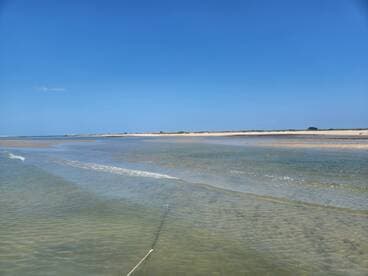 A scenic view of a shallow water area with a sandy beach in the background, ideal for exploring coastal landscapes.