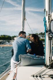 A couple shares a romantic moment aboard a yacht, enjoying the serene views and each other's company — perfect for intimate sailing experiences.