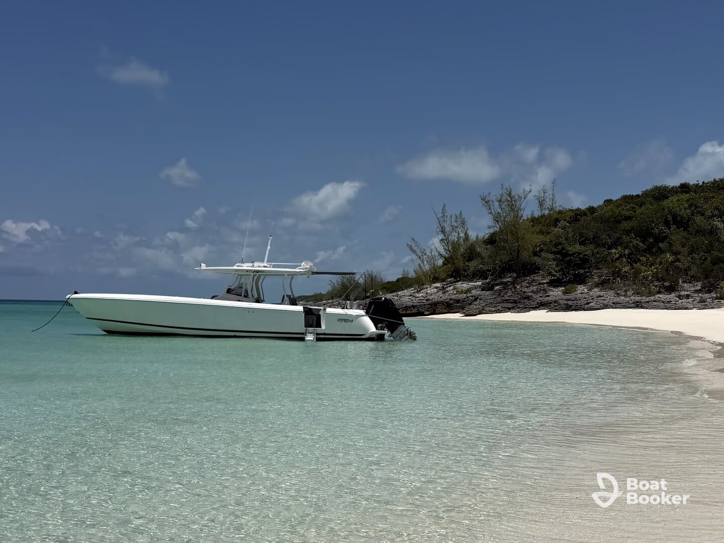 A sleek speedboat anchored in crystal-clear turquoise waters, showcasing the perfect spot for a day of relaxation on the beach.