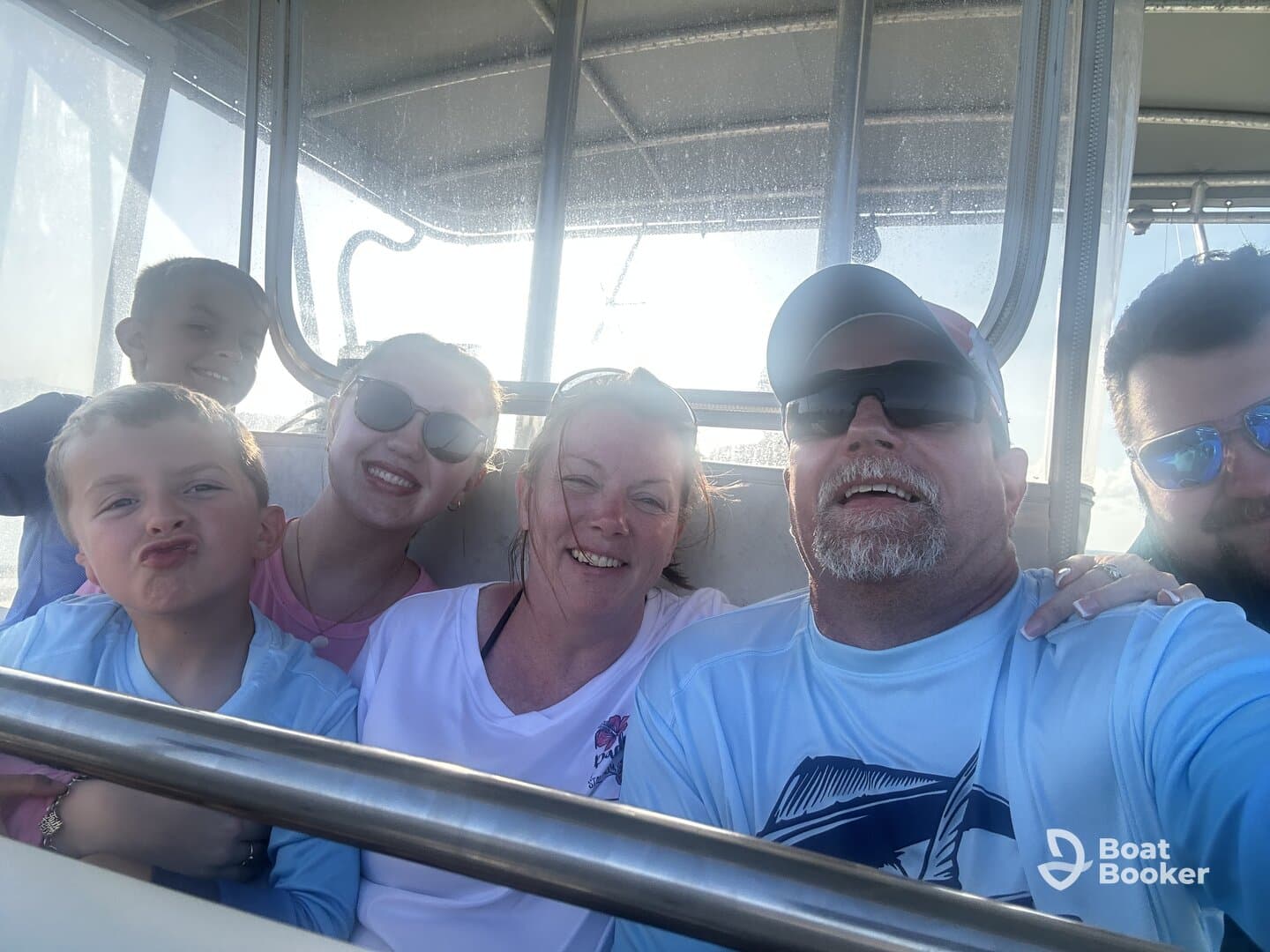 A joyful family captures a fun selfie aboard a boat, showcasing smiles and togetherness during their boating adventure.