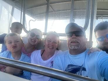 A joyful family captures a fun selfie aboard a boat, showcasing smiles and togetherness during their boating adventure.