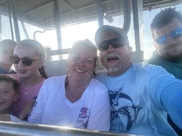 A joyful family captures a selfie aboard a boat, showcasing smiles and togetherness during their aquatic adventure.