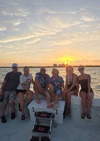 A cheerful group of friends enjoys a sunset on the water, capturing the perfect moment for a memorable boat trip.