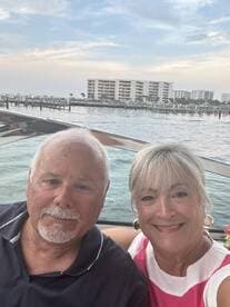 A happy couple enjoys a scenic moment on their boat, capturing the joy of their waterfront experience against a beautiful backdrop.