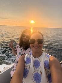 A joyful moment captured at sunset with two friends enjoying a boat ride, perfect for memorable outings and celebrations on the water.