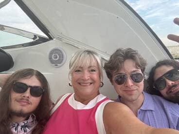 A cheerful group enjoys a fun moment on a boat, capturing a selfie that showcases their excitement and camaraderie on the water.